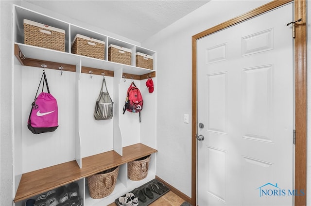 8225 Hidden Forest Dr, Holland, OH 43528 - mudroom with a textured ceiling and baseboards