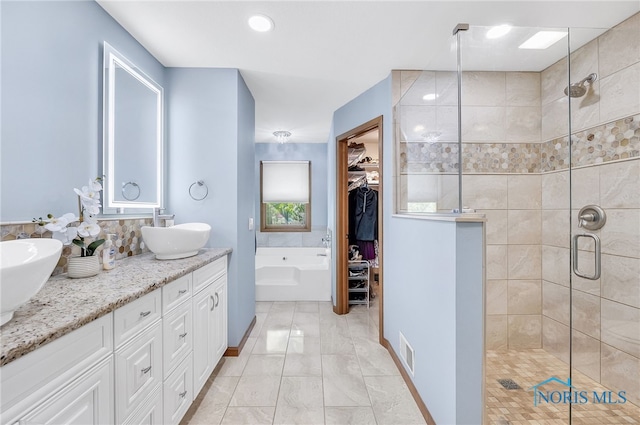 8225 Hidden Forest Dr, Holland, OH 43528 - bathroom with a stall shower, double vanity, a garden tub, and a spacious closet