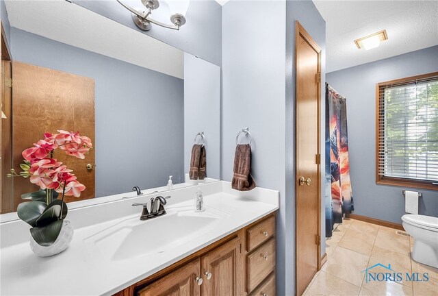 8225 Hidden Forest Dr, Holland, OH 43528 - bathroom featuring vanity, toilet, marble look tiles, and baseboards