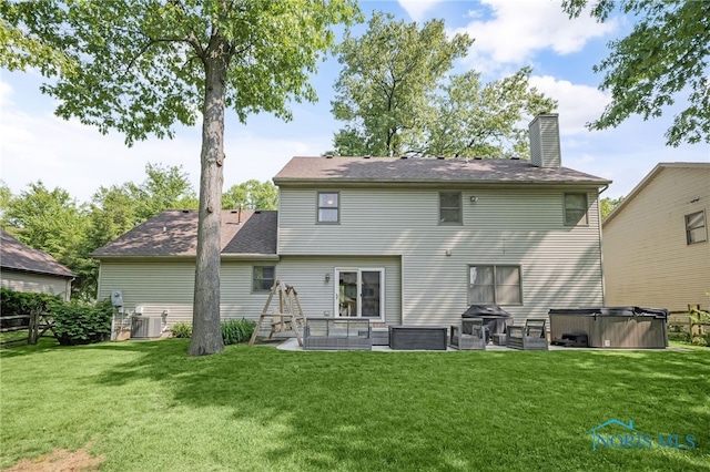 8225 Hidden Forest Dr, Holland, OH 43528 - rear view of house with a hot tub, a yard, a chimney, a patio, and central AC unit