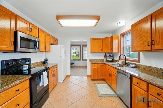 28178 Schriber St, Walbridge, OH 43465 - kitchen with appliances with stainless steel finishes, a sink, brown cabinetry, and light tile patterned floors