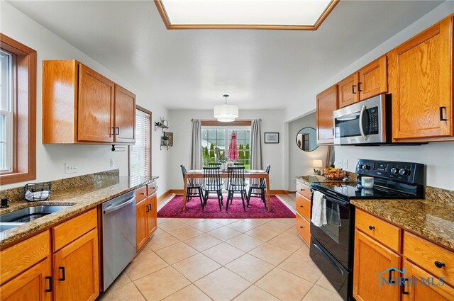 28178 Schriber St, Walbridge, OH 43465 - kitchen with appliances with stainless steel finishes, brown cabinetry, stone countertops, light tile patterned floors, and baseboards