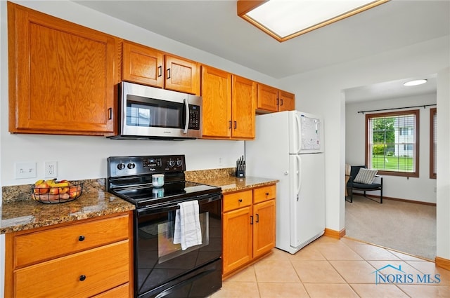 28178 Schriber St, Walbridge, OH 43465 - kitchen with stainless steel microwave, black range with electric cooktop, freestanding refrigerator, brown cabinets, and dark stone counters