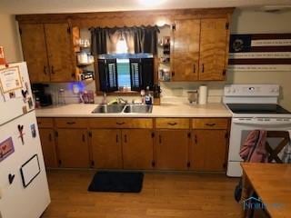129 Central Ave, North Baltimore, OH 45872 - kitchen featuring white appliances, light countertops, wood finished floors, and brown cabinets