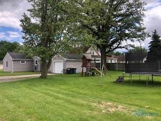 129 Central Ave, North Baltimore, OH 45872 - view of yard featuring a trampoline, a playground, an outdoor structure, and a detached garage