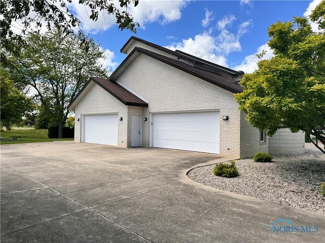 322 Dublin Ln, Bryan, OH 43506 - view of property exterior featuring brick siding, an attached garage, and driveway