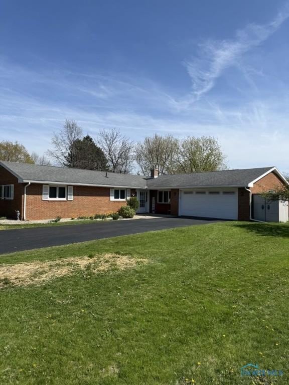 1133 Inverness Dr, Findlay, OH 45840 - ranch-style home featuring brick siding, asphalt driveway, an attached garage, and a front lawn
