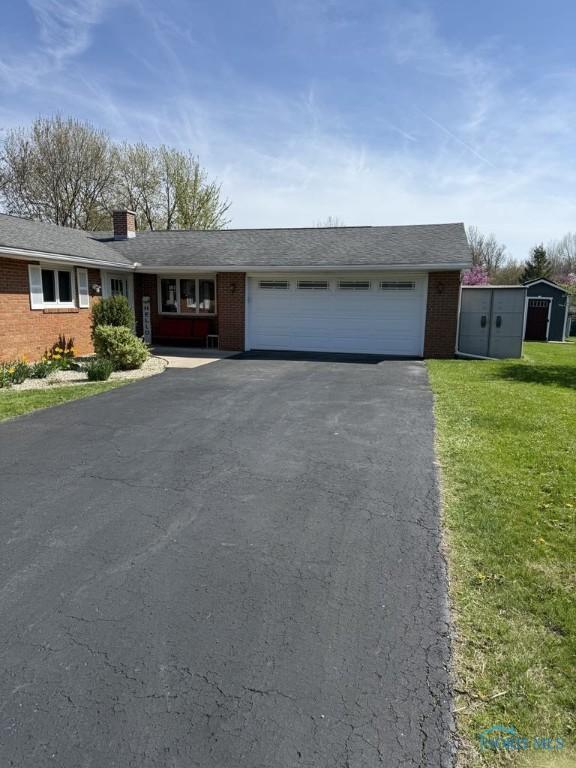 1133 Inverness Dr, Findlay, OH 45840 - single story home with brick siding, driveway, an attached garage, a front yard, and a chimney