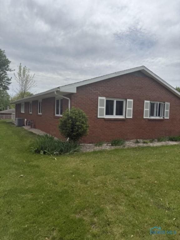 1133 Inverness Dr, Findlay, OH 45840 - view of property exterior featuring brick siding, a yard, and central AC unit