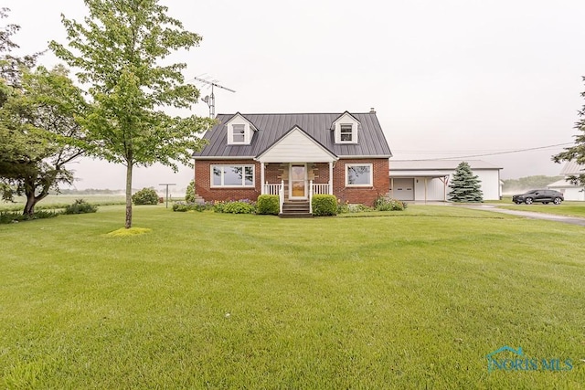 16470 County Road P, Napoleon, OH 43545 - cape cod house featuring brick siding, driveway, a front yard, and a standing seam roof