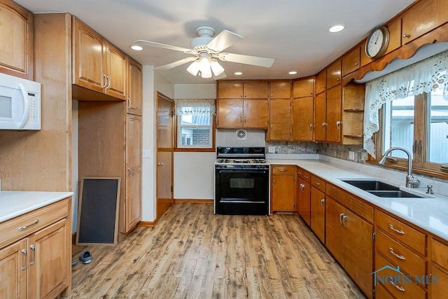 16470 County Road P, Napoleon, OH 43545 - kitchen featuring range with gas cooktop, a sink, ceiling fan, light countertops, and light wood-type flooring