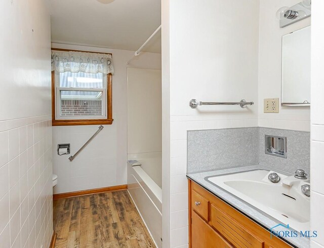 16470 County Road P, Napoleon, OH 43545 - full bathroom featuring tile walls, wood finished floors, vanity, toilet, and bathing tub / shower combination
