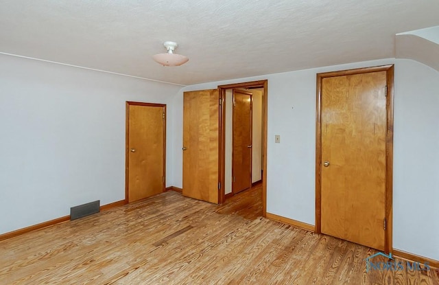 16470 County Road P, Napoleon, OH 43545 - unfurnished bedroom with light wood finished floors, baseboards, and a textured ceiling