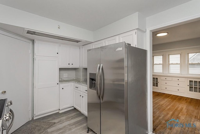 1385 Berdan Ave, Toledo, OH 43612 - kitchen with stainless steel appliances, light wood-style floors, white cabinetry, and light stone countertops