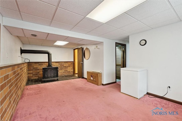 146 Partridge Ln, Perrysburg, OH 43551 - basement featuring a wood stove, a drop ceiling, carpet, baseboards, and fridge