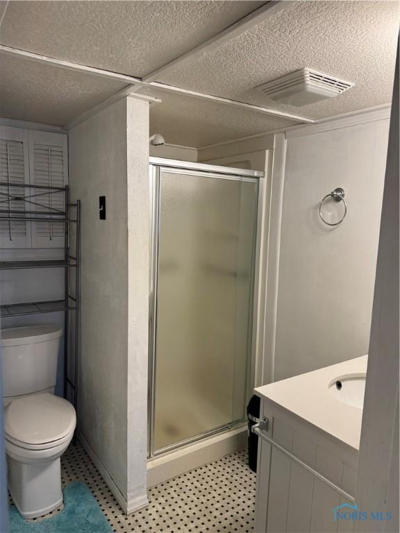 108 E Maple St, Deshler, OH 43516 - full bathroom featuring a stall shower, toilet, vanity, a textured ceiling, and tile patterned floors