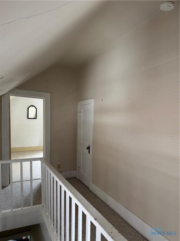 108 E Maple St, Deshler, OH 43516 - hallway featuring vaulted ceiling, carpet floors, and baseboards