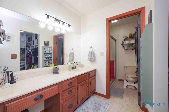 16070 Rd S, Columbus Grove, OH 45830 - full bathroom featuring a walk in closet, vanity, a shower stall, toilet, and baseboards