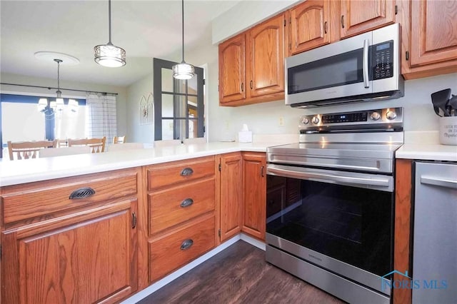 16070 Rd S, Columbus Grove, OH 45830 - kitchen with stainless steel appliances, dark wood finished floors, light countertops, brown cabinetry, and pendant lighting