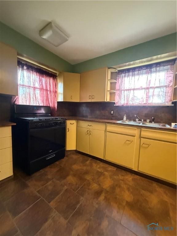 1726 Balkan Pl, Toledo, OH 43613 - kitchen with black gas range oven, a sink, tasteful backsplash, and cream cabinets