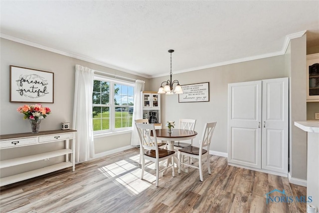 1250 Indiana Ave, Napoleon, OH 43545 - dining space with a chandelier, ornamental molding, light wood-style floors, and baseboards