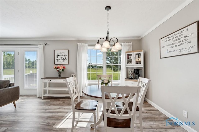 1250 Indiana Ave, Napoleon, OH 43545 - dining room with a chandelier, healthy amount of natural light, crown molding, wood finished floors, and baseboards