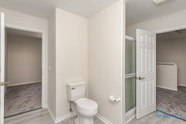 4022 Stonehenge Dr Unit 4022, Sylvania, OH 43560 - bathroom with a shower stall, baseboards, toilet, and wood finished floors