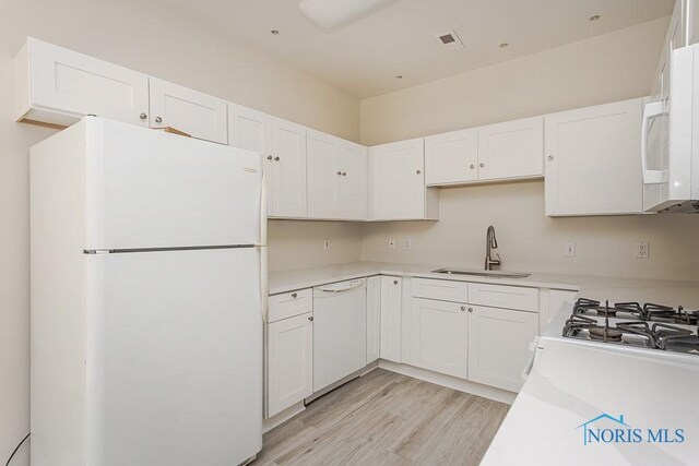 4022 Stonehenge Dr Unit 4022, Sylvania, OH 43560 - kitchen featuring white appliances, a sink, white cabinetry, light wood-type flooring, and light countertops