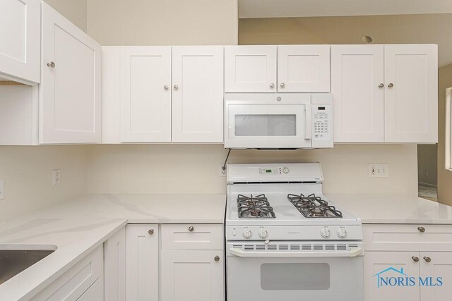 4022 Stonehenge Dr Unit 4022, Sylvania, OH 43560 - kitchen featuring white appliances, white cabinetry, light stone counters, and a sink