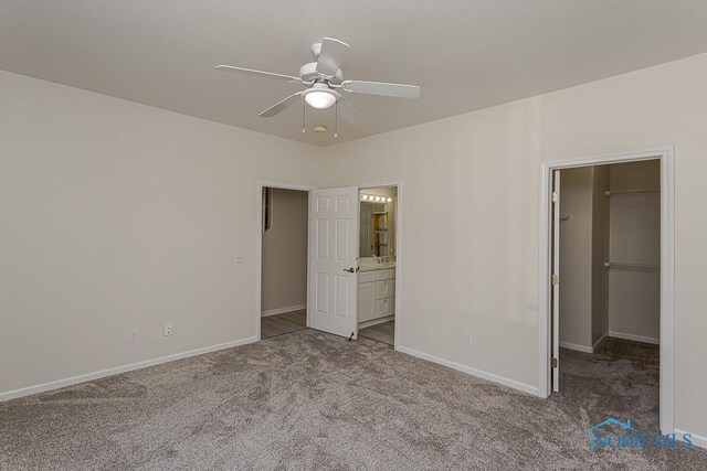 4022 Stonehenge Dr Unit 4022, Sylvania, OH 43560 - unfurnished bedroom with a spacious closet, carpet floors, baseboards, ensuite bath, and ceiling fan