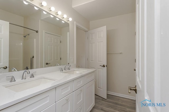 4022 Stonehenge Dr Unit 4022, Sylvania, OH 43560 - bathroom with double vanity, baseboards, wood finished floors, and a shower