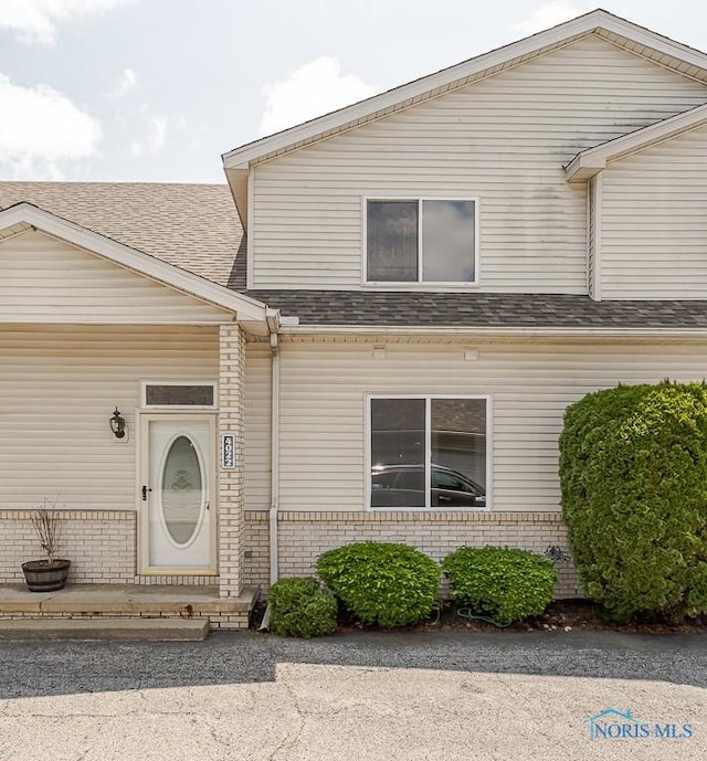 4022 Stonehenge Dr Unit 4022, Sylvania, OH 43560 - doorway to property with roof with shingles and brick siding