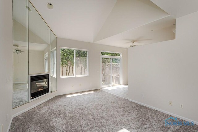 4022 Stonehenge Dr Unit 4022, Sylvania, OH 43560 - unfurnished living room with ceiling fan, vaulted ceiling, carpet flooring, baseboards, and a glass covered fireplace