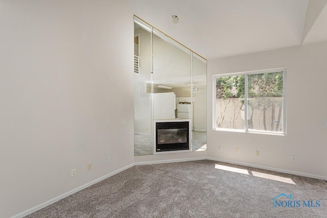 4022 Stonehenge Dr Unit 4022, Sylvania, OH 43560 - unfurnished living room featuring a glass covered fireplace, carpet flooring, baseboards, and lofted ceiling