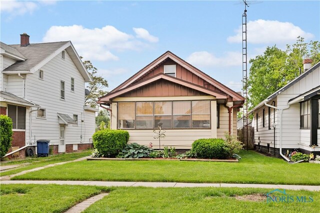1006 Woodward Ave, Toledo, OH 43608 - view of front of home with board and batten siding and a front yard