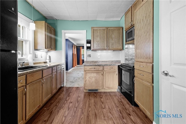 1006 Woodward Ave, Toledo, OH 43608 - kitchen with black appliances, dark wood finished floors, a sink, and decorative light fixtures