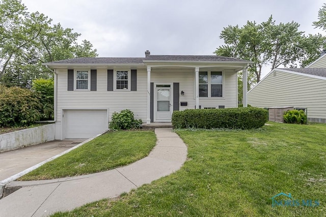 1201 Birch Ave, Maumee, OH 43537 - raised ranch featuring concrete driveway, an attached garage, a front lawn, and a chimney