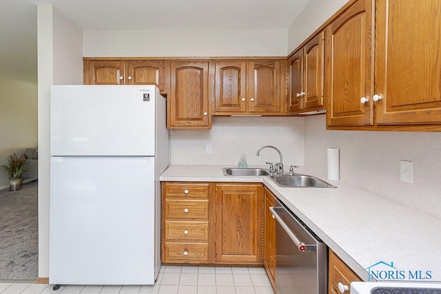 1201 Birch Ave, Maumee, OH 43537 - kitchen featuring freestanding refrigerator, stainless steel dishwasher, light countertops, and a sink