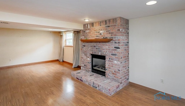 1201 Birch Ave, Maumee, OH 43537 - unfurnished living room with wood finished floors, a brick fireplace, baseboards, and recessed lighting