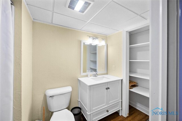 26741 Green Ville Dr, Perrysburg, OH 43551 - bathroom featuring vanity, toilet, wood finished floors, and a drop ceiling