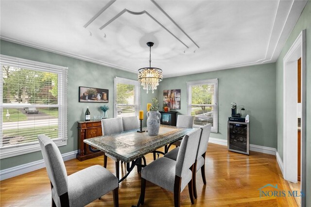 26741 Green Ville Dr, Perrysburg, OH 43551 - dining area with beverage cooler, light wood-style flooring, a chandelier, and baseboards