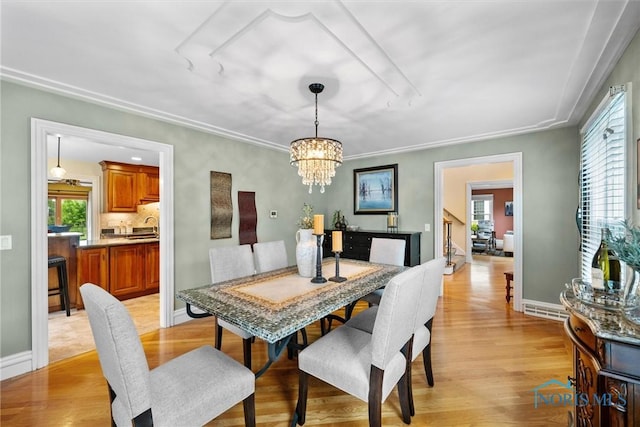 26741 Green Ville Dr, Perrysburg, OH 43551 - dining area featuring a chandelier, healthy amount of natural light, light wood-style flooring, and baseboards