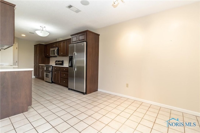 5831 Monroe St Unit 602, Sylvania, OH 43560 - kitchen featuring appliances with stainless steel finishes, light countertops, dark brown cabinetry, light tile patterned floors, and baseboards