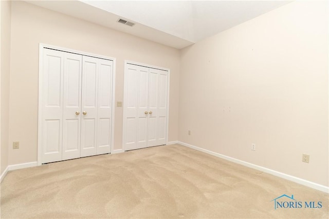 5831 Monroe St Unit 602, Sylvania, OH 43560 - unfurnished bedroom featuring multiple closets, light carpet, and baseboards