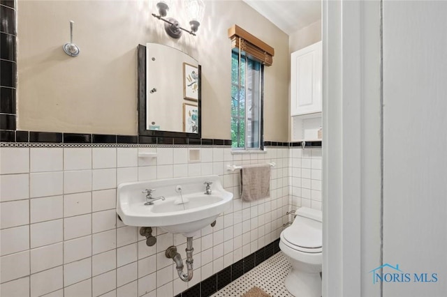 2256 Barrington Dr, Toledo, OH 43606 - bathroom with toilet, tile walls, wainscoting, and tile patterned flooring