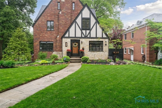 2256 Barrington Dr, Toledo, OH 43606 - tudor-style house featuring a front yard, stone siding, and stucco siding