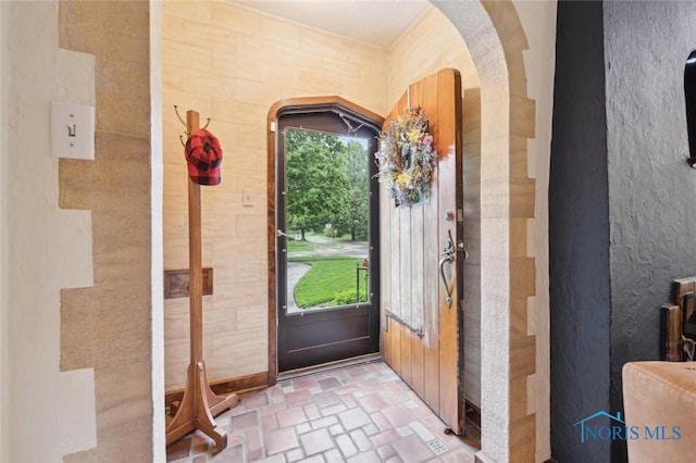 2256 Barrington Dr, Toledo, OH 43606 - foyer entrance with brick patterned flooring, arched walkways, and a textured wall