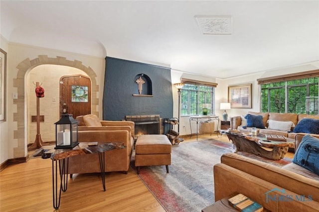 2256 Barrington Dr, Toledo, OH 43606 - living area with light wood-style flooring, arched walkways, a large fireplace, baseboards, and crown molding