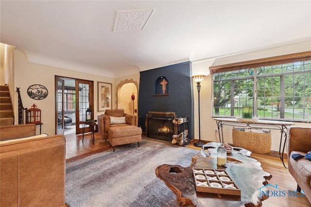 2256 Barrington Dr, Toledo, OH 43606 - living area featuring wood finished floors, a lit fireplace, stairs, and arched walkways