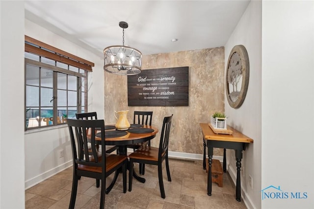 2256 Barrington Dr, Toledo, OH 43606 - dining space featuring baseboards, a chandelier, and stone finish floors